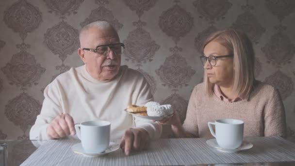 Kvinna ger leende make tallrik med läckra kakor — Stockvideo