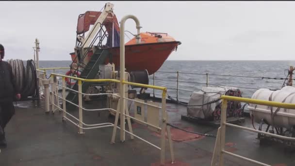 Professional videographer walks along oil tanker stern — Stock Video