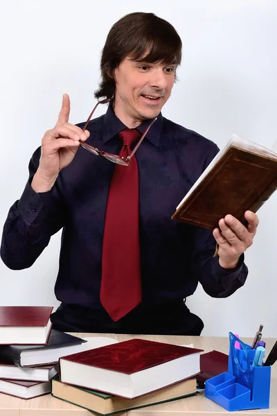 Professor-cientista masculino segurando em seus óculos de mão segurando um dedo para cima com entusiasmo lê o livro — Fotografia de Stock