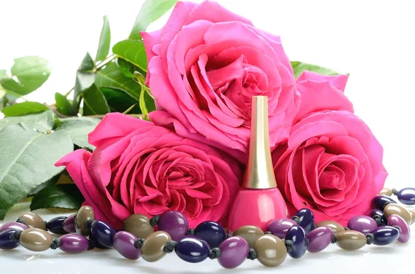 Три розовых розы и лак для ногтей, бусы — стоковое фото