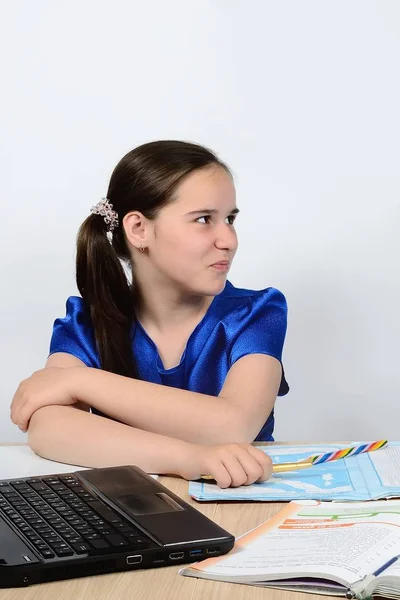 Écolière adolescente pour le bureau de l'école à un portrait d'ordinateur sur fond — Photo