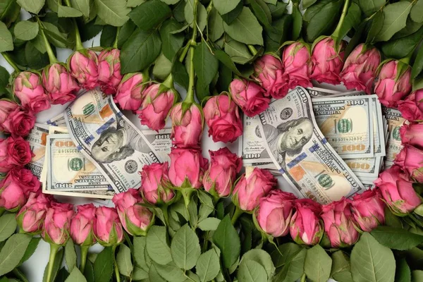 Layed in the number 8 in two circles of flowers pink roses in the center hundred-dollar cash notes original gift for the celebration