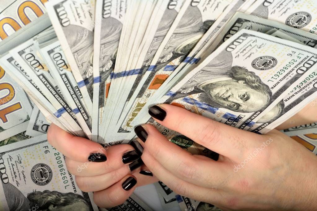 Close-up of female hands with manicure hold money hundred-dollar bills on white background