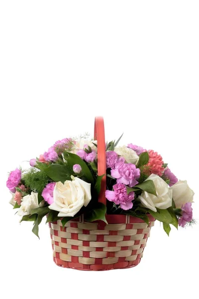 白の背景の籐のバスケットにさまざまな色の花束 美しいバラの花 花屋の休日仕事おめでとうのライラックとピンクのカーネーション ロイヤリティフリーのストック写真