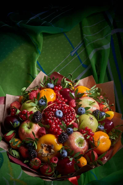 A delicious bouquet of healthy vitamin fruits and berries: strawberries, pomegranates, currants, persimmons, blueberries, tangerines.
