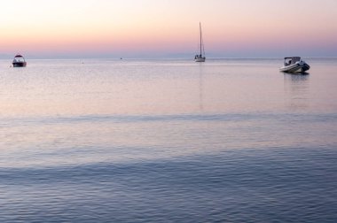 Zakynthos Adası, Yunanistan. Unutulmaz deniz tatilleri için uygun plajları ve kıyıları olan Akdeniz incileri. Gündoğumunda Agios Nikolaos Sahili 'nde yelkenli..
