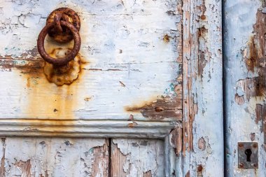 Antik İtalyan evi: tipik boyanmış ahşap kapının ayrıntıları, zamanla aşınmış, paslı demir bir tokmakla..