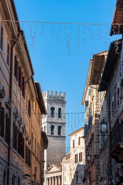 Assisi, the city of peace, Italy. UNESCO World Heritage Site, the birthplace of Saint Francis. Detail of the ancient village with the municipal tower, of the Temple of Minerva, in the background.