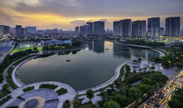 Edifici con riflessi sul lago al tramonto al parco Thanh Xuan. Hanoi paesaggio urbano al crepuscolo periodo — Foto Stock