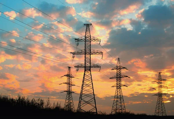 高電圧送電線。夕日を背景にシルエット電気ポスト ロイヤリティフリーのストック画像