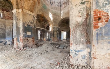 Terk edilmiş bir yağmalanmış tapınak içinde. Sütunlar ve dağılan boya ve sıva ile bir kubbe