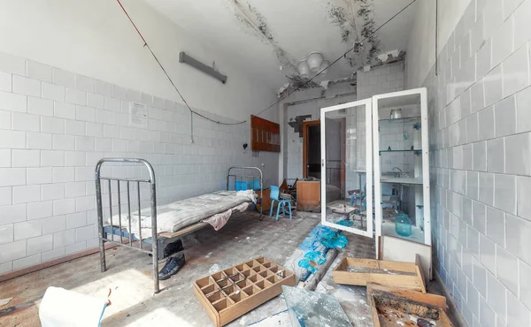 Abandoned and destroyed medical room with a medical bed.