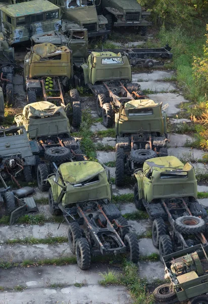 O grupo enferrujado velho caminhão do exército abandonado em uma plataforma de concreto — Fotografia de Stock