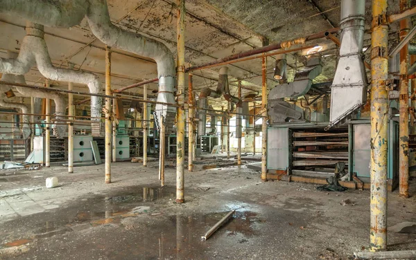 Destroyed production room of an old abandoned textile factory wi — Stock Photo, Image