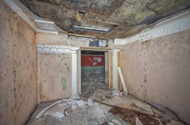 Bir eski terk edilmiş Sovyet barınağı dekoratif antik sütun ve yere çöp odasında. Kalıp ile nemlendirilmiş asma tavan.