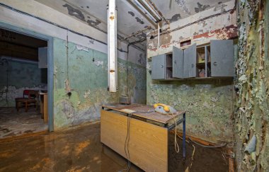 Bir su dolu, eski püskü terk edilmiş soğuk savaş saldırısı sığınağı vintage bir telefon ile eski tablo