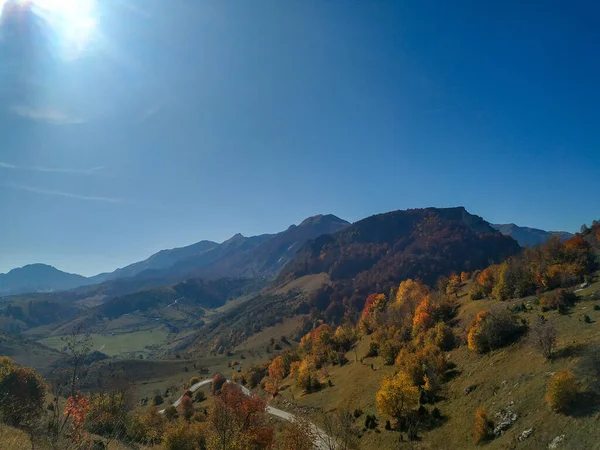 Güneş ışığı güzel bir çayır ve tepenin rengarenk doğası. Sonbahar günü orman ve çimlerle kaplıdır. Açık havada yürüyüş yapmak için birebirdir.