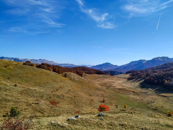 Papel de parede para sonho como a vista de montanha fantasia e um vasto campo verde com pequeno rio passando enquanto passa um dia no majestoso ambiente natural — Fotografia de Stock