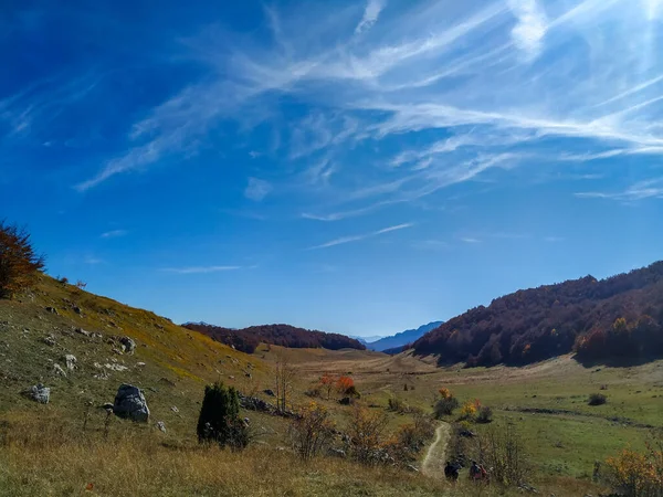 Vista serena da montanha de um vasto campo de grama verde e colinas ao redor como um ambiente idílico durante um majestoso dia de outono para caminhadas e caminhadas na natureza — Fotografia de Stock