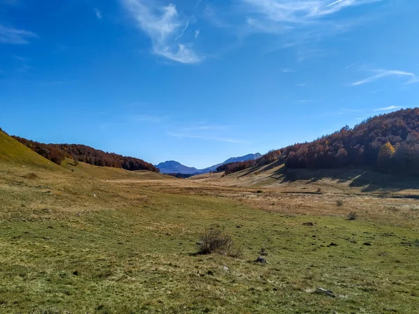 Procurando novas experiências durante uma viagem na natureza isolada cercada por majestosas montanhas, colinas e campos de grama em ambiente tranquilo — Fotografia de Stock