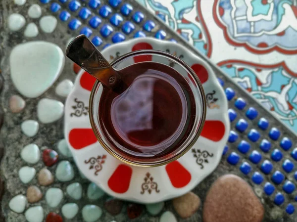 Turkish black tea in glass cup and plate served on colorful table during teatime in Turkey as hot delicious beverage drink — Stock Photo, Image