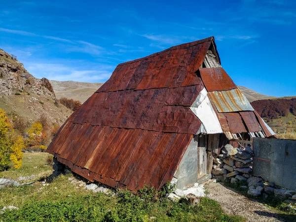 Balkanlar 'ın ıssız bir köyünde, paslı çatısı ve güzel doğası olan eski bir dağ evi.