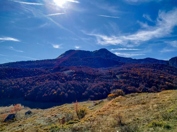 Énorme pic de montagne pittoresque avec forêt sur le sol et vallée d'herbe verte tout en grimpant dans la nature pendant l'automne coloré — Photo