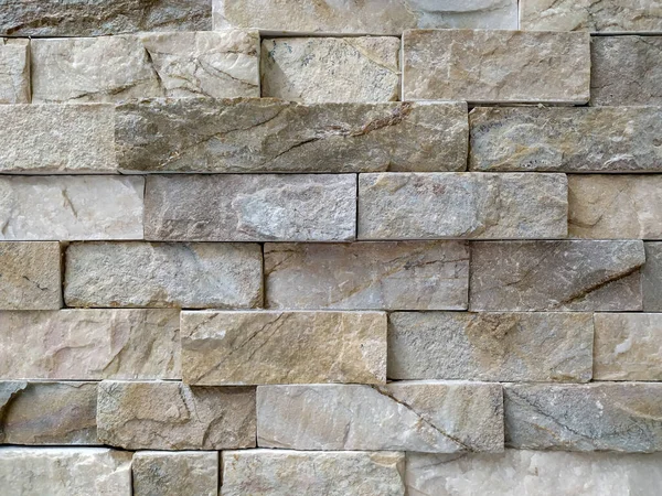 Modern stil mimarisinin pürüzsüz yüzeyi. İç veya dış dekorasyon için modern desenli taş duvar.