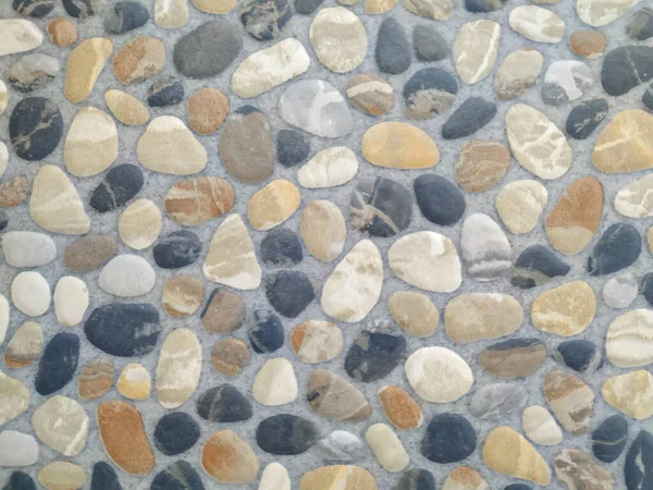 Petites pierres et rochers alignés dans un bloc solide dur comme décoration pour mur ou sol — Photo
