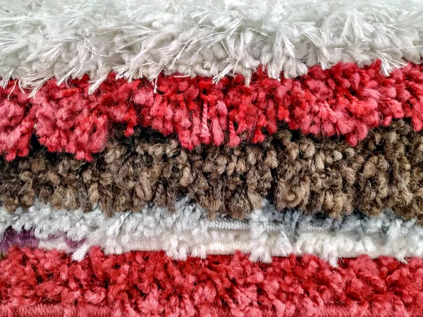 Diferentes alfombras de alfombra de colores apilados entre sí para la venta, material de lana muy cálido y suave para la decoración y cobertura de interiores —  Fotos de Stock