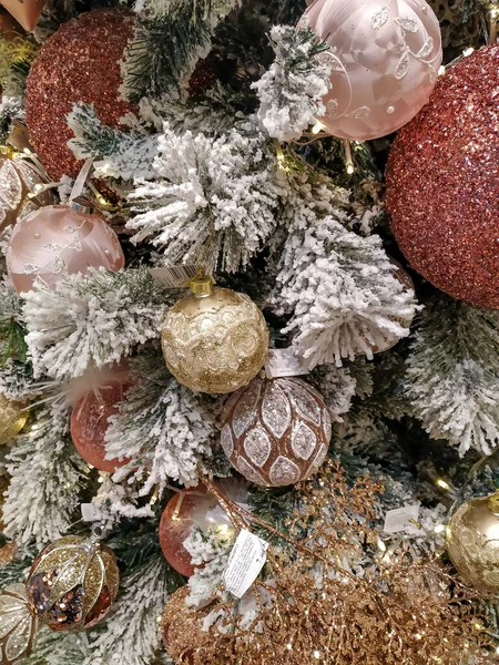 Hermosos adornos festivos en un árbol de Navidad con agujas de pino blanco y decoraciones congeladas en múltiples colores —  Fotos de Stock