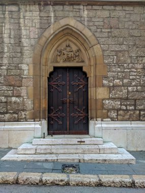 Saraybosna 'daki katedral girişi ahşap kapı. Süsler, dekorasyonlar ve antik tarihi taş duvarlarla çevrili.