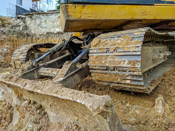 Escavador amarelo, escavadeira ou escavadeira trabalhando em local lamacento e sujo com tecnologia moderna para limpar o chão para nova construção e desconstrução — Fotografia de Stock