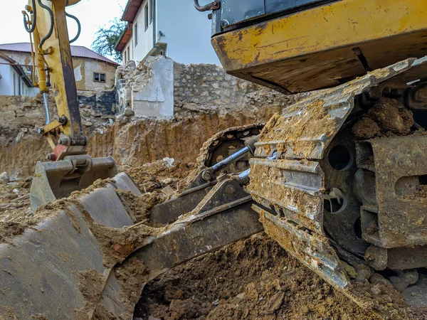 Primer plano de excavadora amarilla, excavadora o excavadora que trabaja en la excavación del sitio, cavando el suelo para la nueva construcción moderna que tendrá lugar —  Fotos de Stock