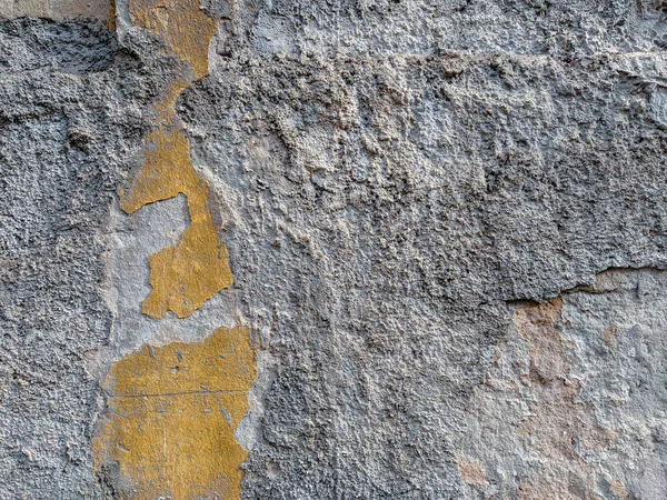 Груба текстура стіни старої будівлі з ознаками розпаду і пошкодження, шматочки фасаду, залишені зі старим цементом, що показує як холодний фон або шпалери — стокове фото