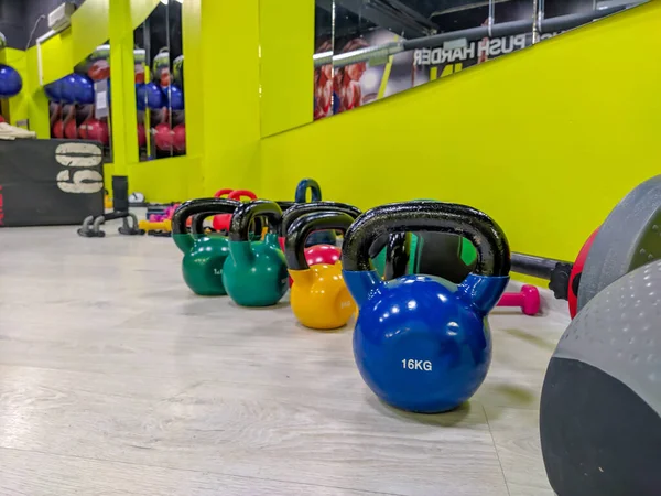 Weight dumbbells in the shape of balls in different colors for strength training and bodybuilding in a modern gym as a healthy lifestyle workout — Stock Photo, Image