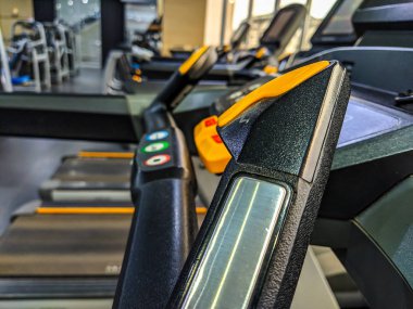 Kilo vermek için iyi donanımlı bir spor salonunda modern ve iyi görünümlü koşu bandı sapları ve makineleri ve sağlıklı bir yeni yıl çözünürlüğünün sembolü.