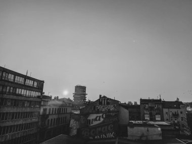 Saraybosna 'da serin bir günbatımının siyah ve beyazı. Eski tarz binalar ilginç geçmişe dönük mimari ile gökyüzüne yükseliyor.