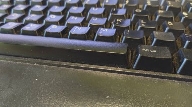 Kirli siyah bir klavyeye çok fazla toz ve tuş arasında sıkışmış, bakteri ve alerji riski var.