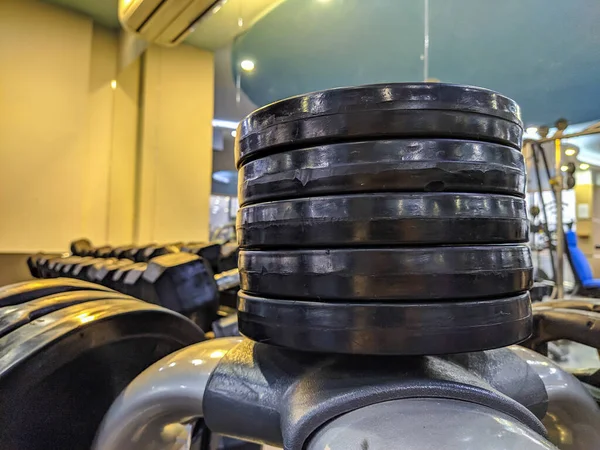 Βαρέα μέταλλα δίσκους βάρους για bodybuilding και άρση βαρών στοιβάζονται ο ένας στον άλλο σε ένα σύγχρονο και καλά εξοπλισμένο γυμναστήριο για υγιή τρόπο ζωής και την απώλεια βάρους — Φωτογραφία Αρχείου