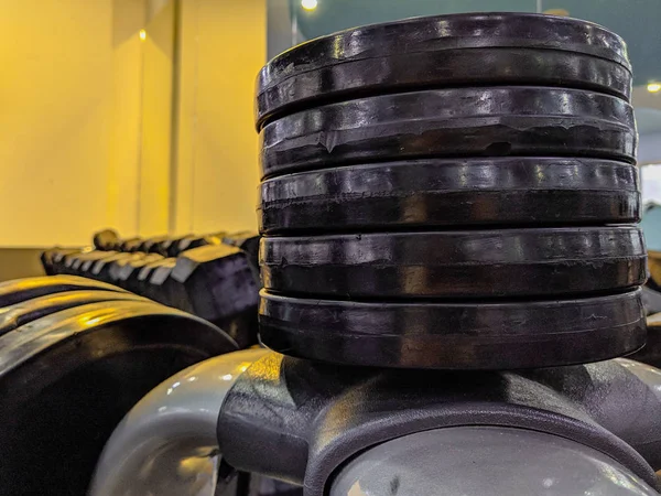Heavy metal weight disks for bodybuilding and weight lifting stacked on each other at a modern and well equipped gym for recreational or professional bodybuilding