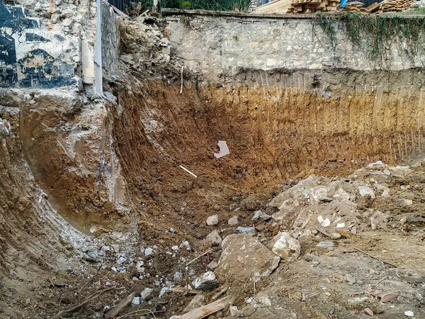 Escavadora bulldozer enorme de trabalho entre o terreno sujo do local de escavação durante a escavação e trabalho em reparos — Fotografia de Stock