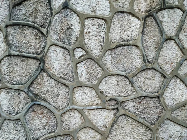 Fond de mur de pierre de roche en briques sur un mur du bâtiment à l'extérieur avec une texture rugueuse et un motif naturel intéressant collé avec du ciment — Photo