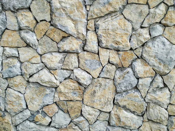 Modern rock stone wall background made of bricks on a wall of the building for the outdoors walls with rough texture and interesting antique retro natural pattern