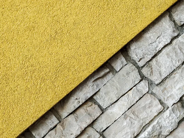 Fond d'écran cool avec un côté de la diagonale dans le mur lisse en couleur jaune et de l'autre côté en briques de pierre sur le gabarit de mur — Photo