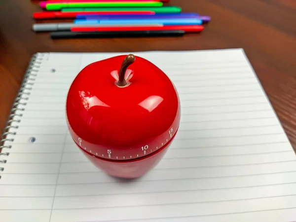 Técnica de estudio Pomodoro con un temporizador de cocina en forma de manzana para establecer una alarma para una mejor productividad y sesiones de estudio para superar la dilación — Foto de Stock