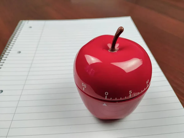Closeup of kitchen timer in apple shape as a pomodoro study technique for timing study sessions and beating procrastination