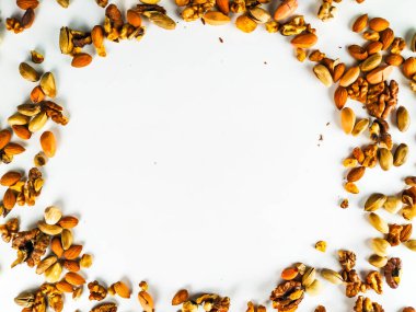 Sağlıklı ve besleyici organik renkli fındık karışımı görüntünün köşelerinde sağlıklı bir diyet sunarak bir çember oluşturur.