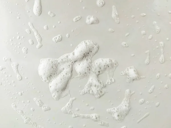 Closeup of white detergent foam and bubbles on white surface background while doing the washing and cleaning in the house — Stock Photo, Image