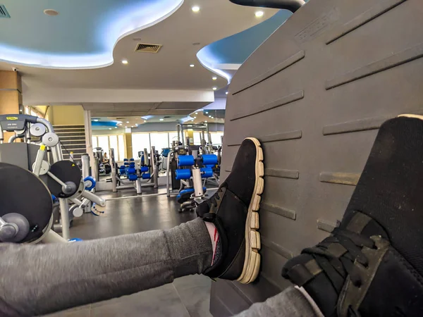 Zbliżenie nóg człowieka podczas wykonywania treningu w siłowni pchanie na platformie dla zwiększenia wysiłku i odchudzania — Zdjęcie stockowe